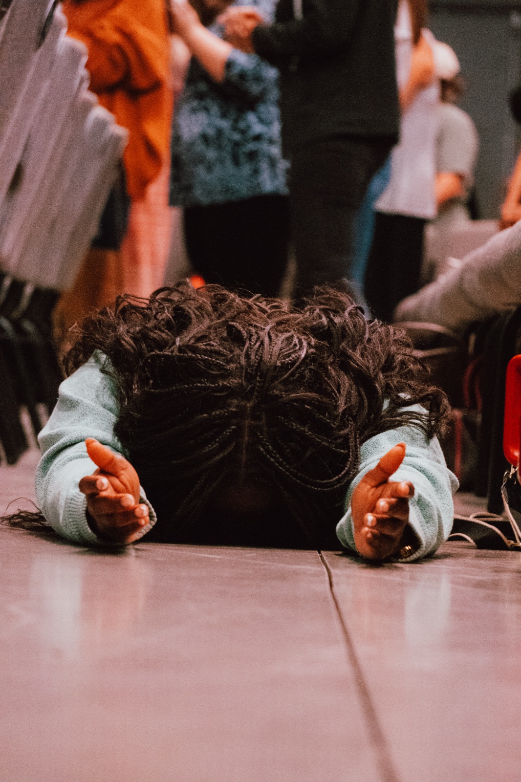 A woman in prayer on the floor during worship